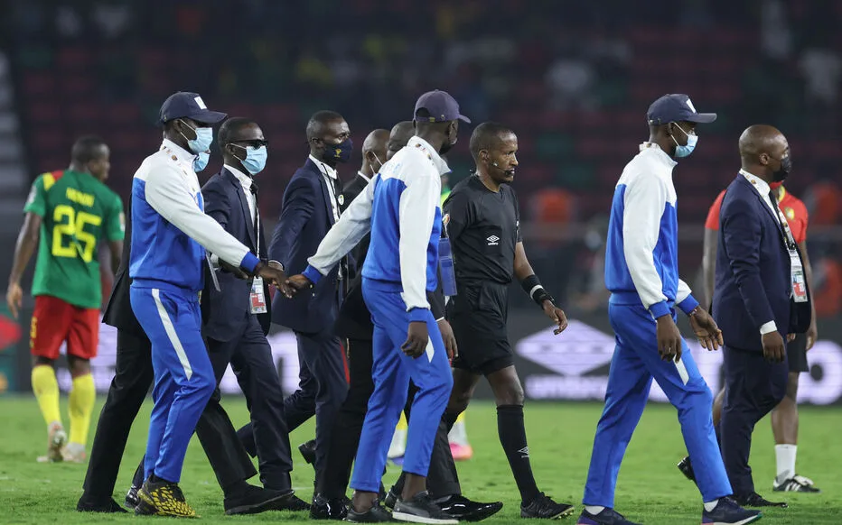 Security escourt Ethiopian referee Bamlak Tessema Weyesa (3rd R) off the field during the Africa Cup of Nations (CAN) 2021 round of 16 football match between Cameroon and Comoros at Stade d'Olembe in Yaounde on January 24, 2022. (Photo by Kenzo Tribouillard / AFP)